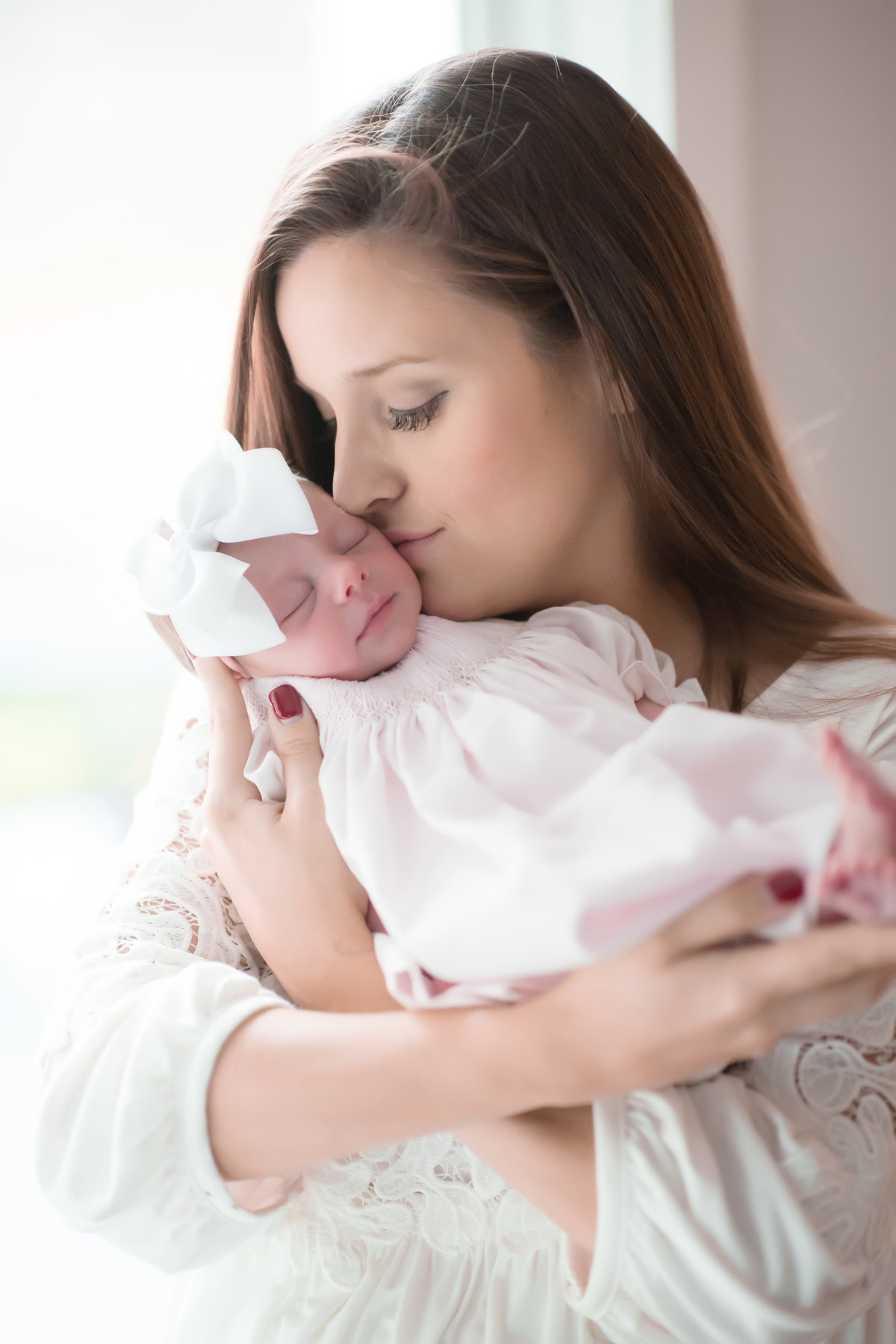 mother kissing baby girl