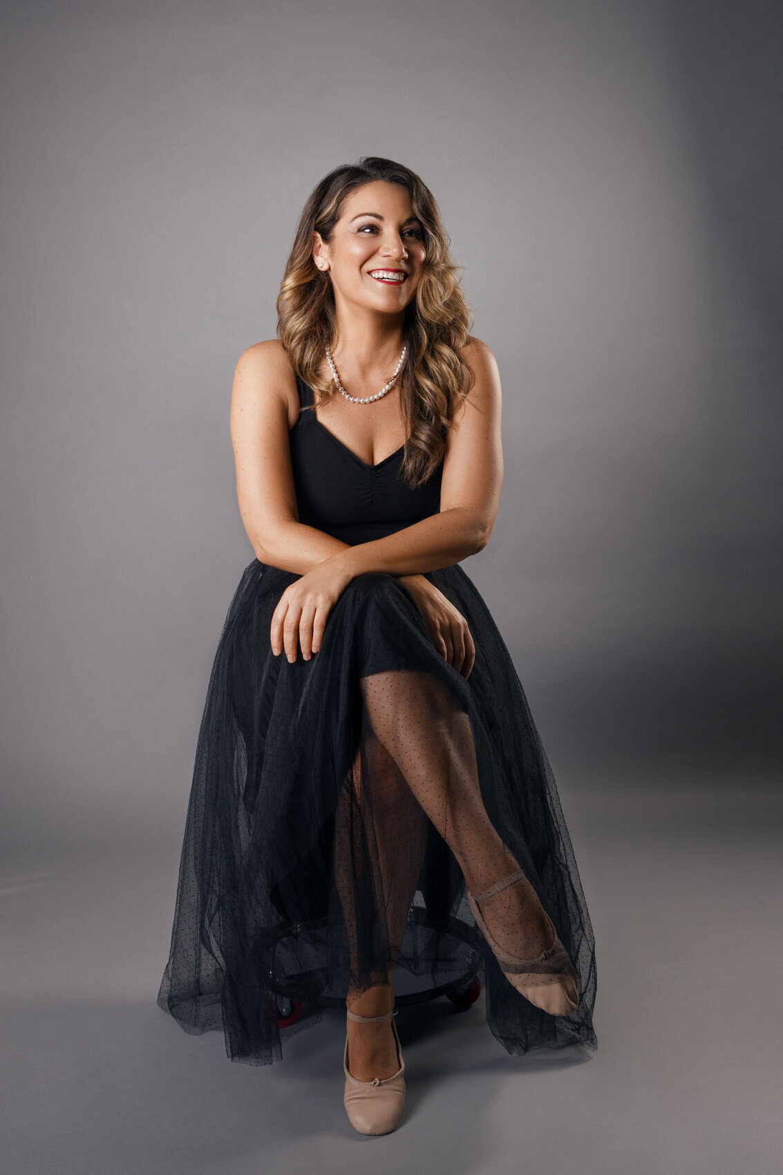Elegant portrait of Christina in a black gown, seated gracefully, captured by Ylva Erevall.