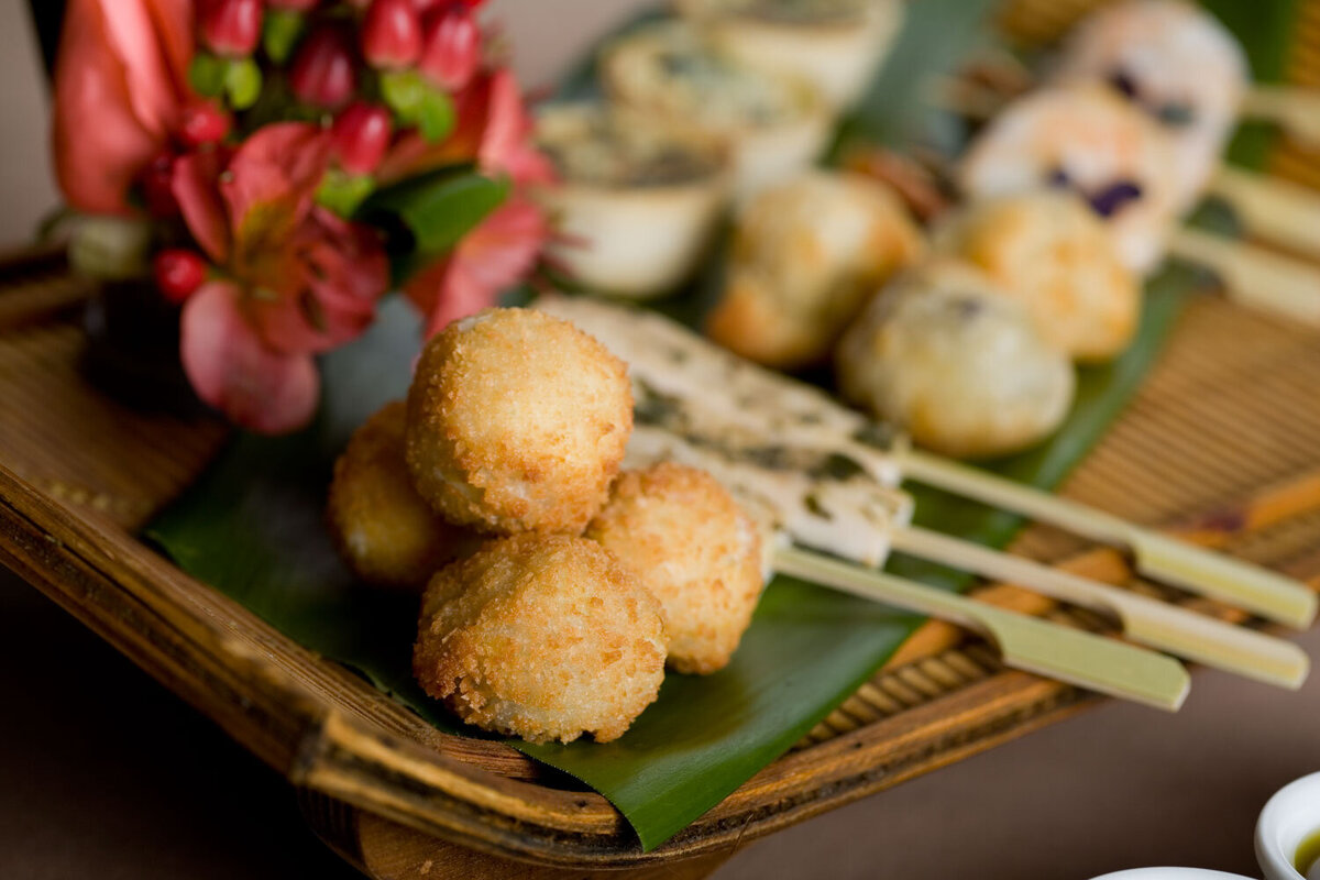 A close up of shrimp on skewers on a green leaf