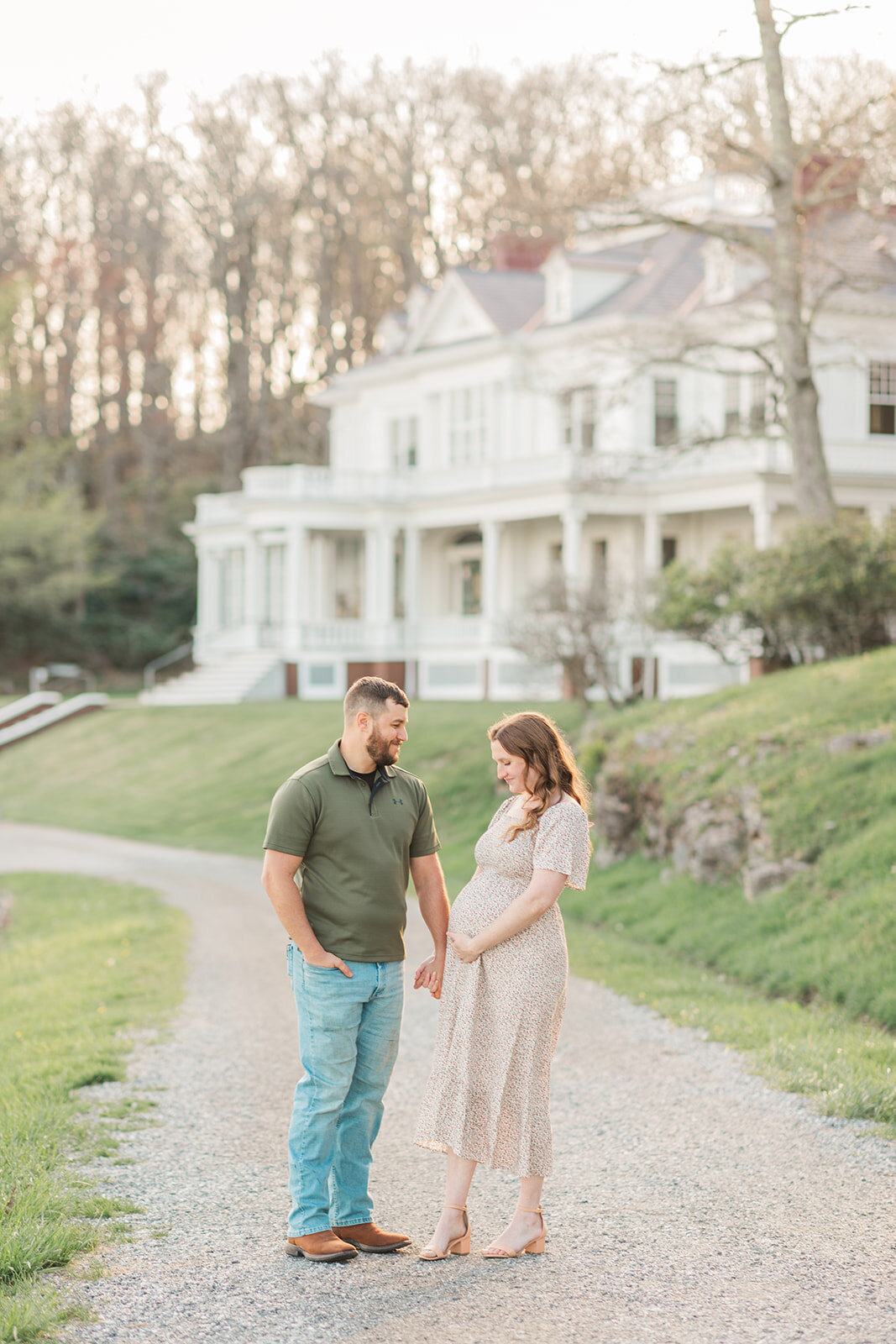 Expecting parents holding hands at Moses Cone Manor