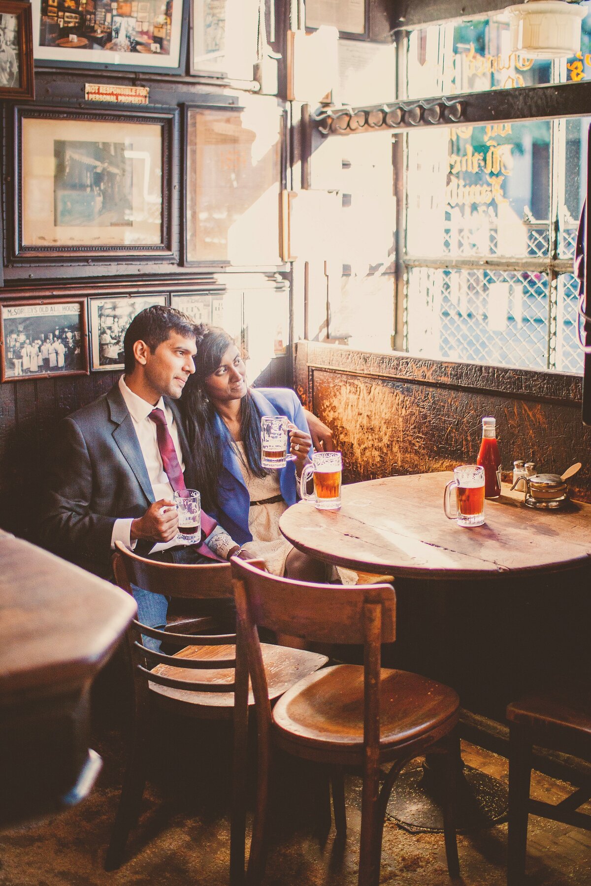 A couple having a beer together sitting down at an old irish pub mcSorley's old ale house in nyc