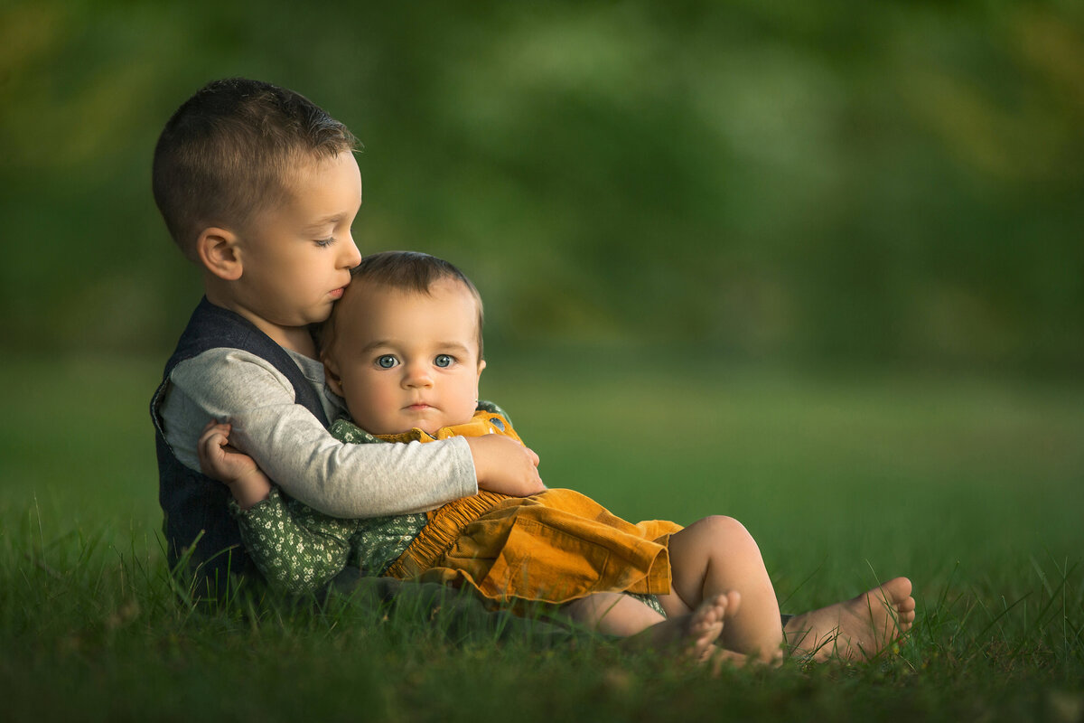 Siblings hug for photos during family photography session at Marquand Park in Hamilton, New Jersey