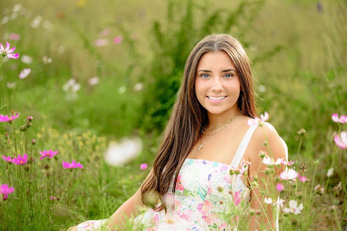 cuthbertson high school graduate leans against a wall wearing a green crop top with jeans