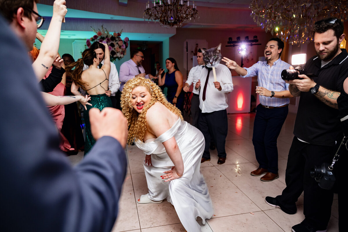 Shannon Lee, from Love Like Wild Photography, captures a joyful bride dancing energetically on the dance floor surrounded by guests.
