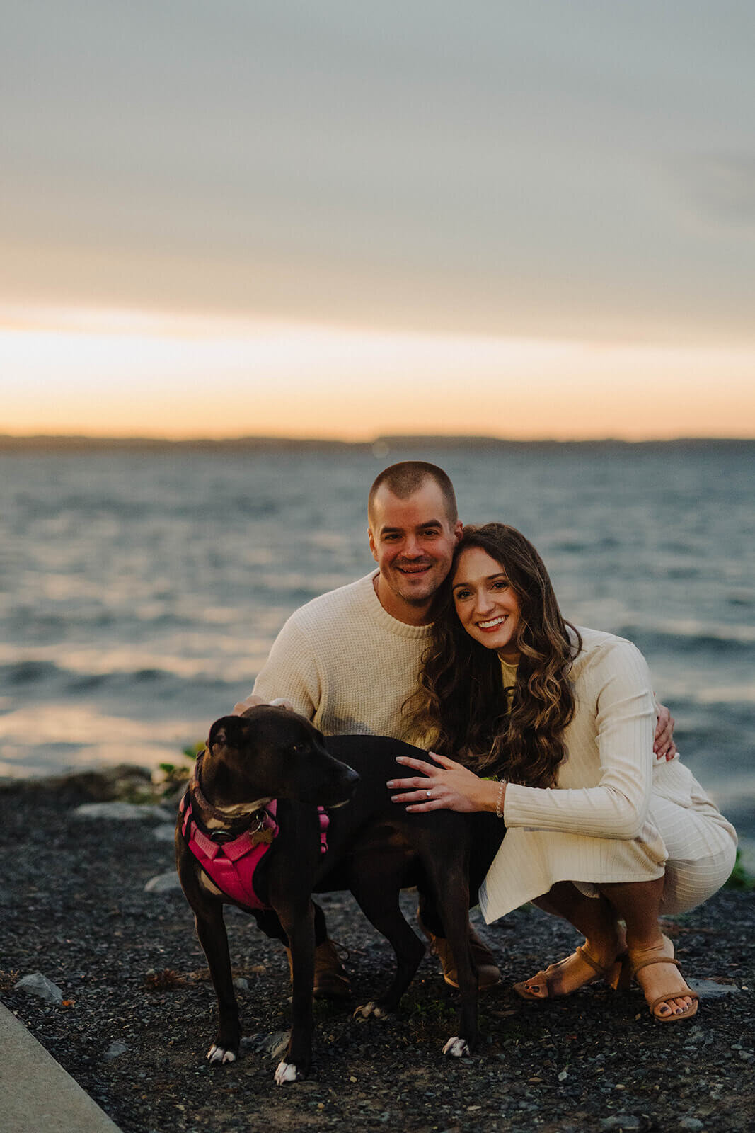 Couple with dog by edge of a lake at Finger Lakes engagement session