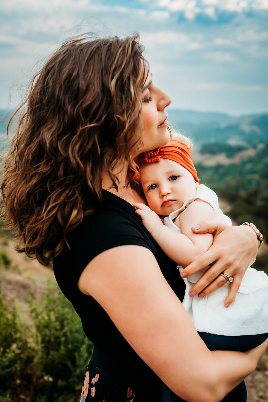 mama snuggling her baby girl in the East Bay hills