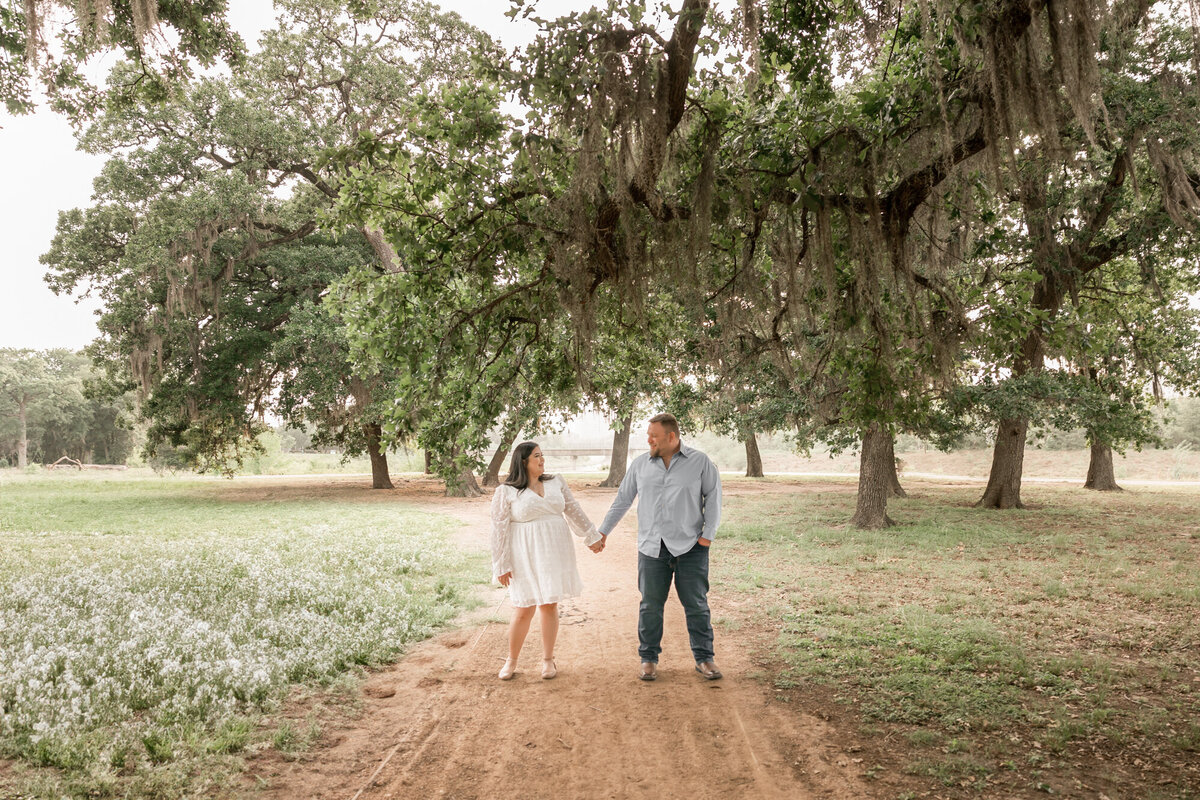 fiances hold hands during their engagement session in houston with allyson blankenburg