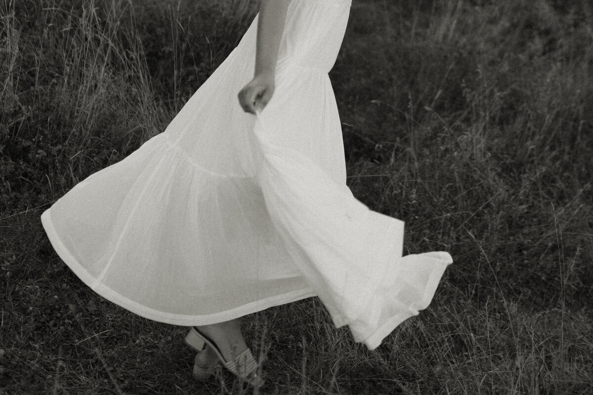 A high school senior twirls her dress as she runs along Minnesota Point Beach, photographed by a Duluth Senior Photographer.