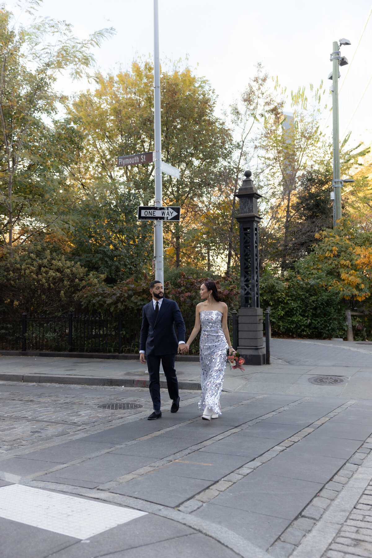 A candid shot of the couple laughing together on the iconic cobblestone streets of DUMBO, Brooklyn.