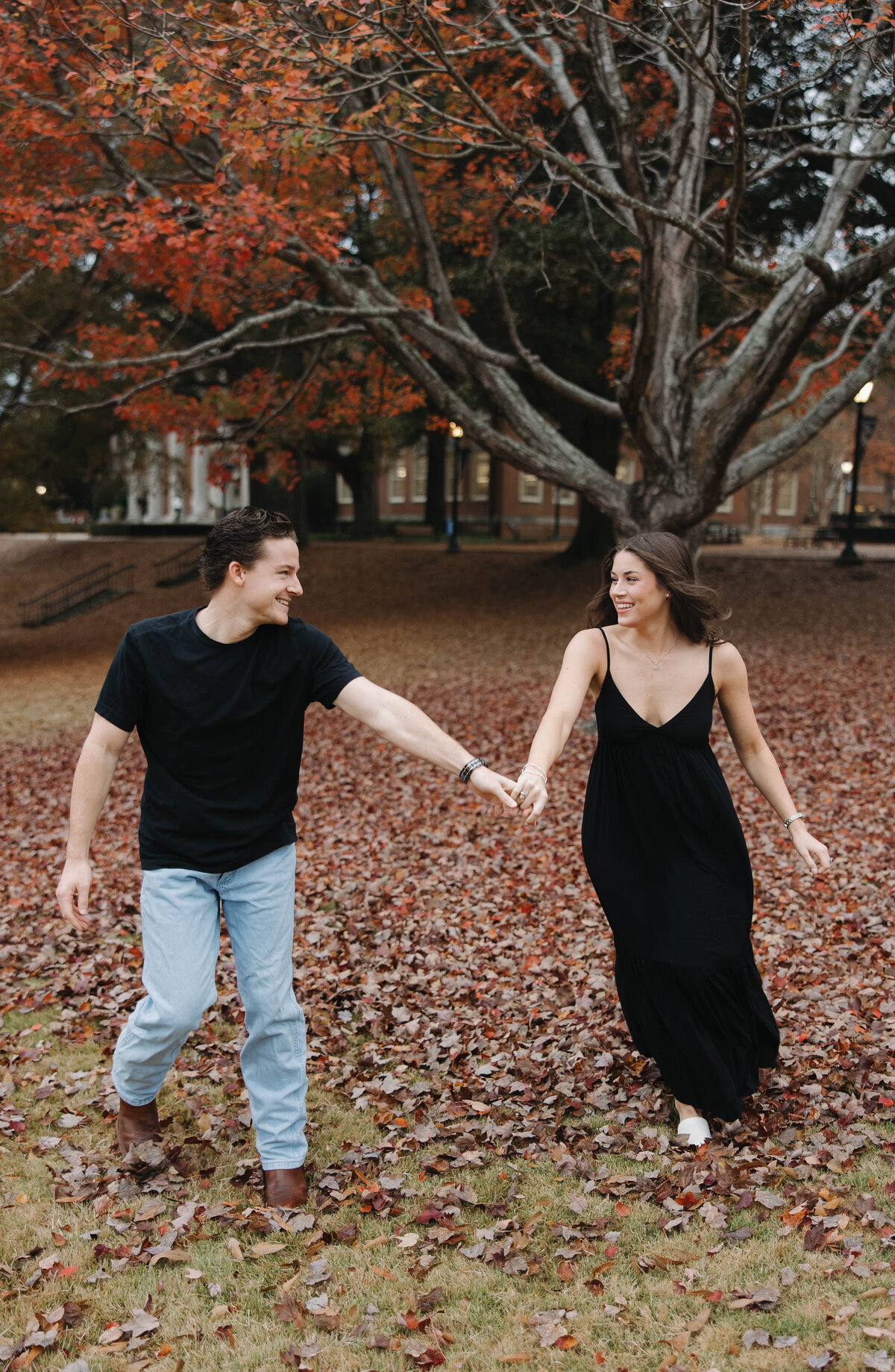couple walking together through the fall leaves