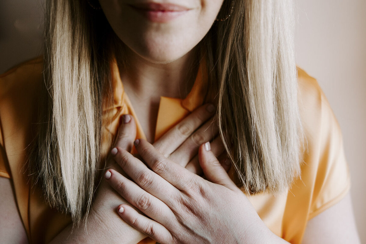a woman praying with her hands on her chest