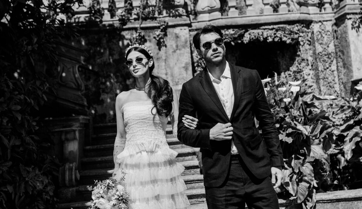 Chic couple in bridal attire outside Dior chateau in Lake Como, Italy
