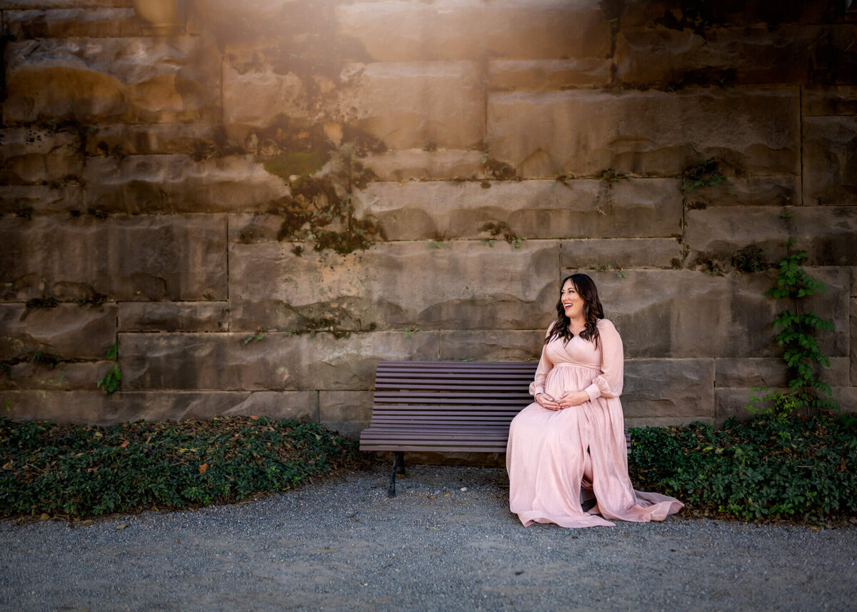 A beautiful woman sits  on a bench  at the Biltmore Estate