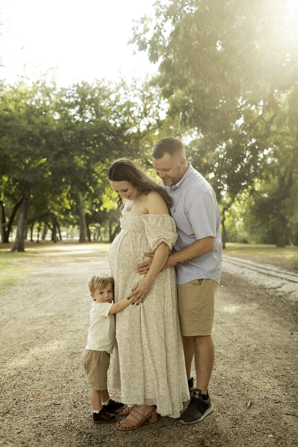 A heartwarming family maternity session at Trinity Park, with mom and dad holding hands while their big brother proudly touches mom’s baby bump, captured by Chunky Monkey Photography.