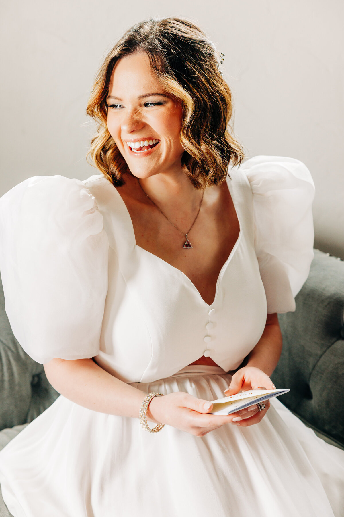 Bride holding vow book and laughing at Fox Fields in Red Lodge, MT