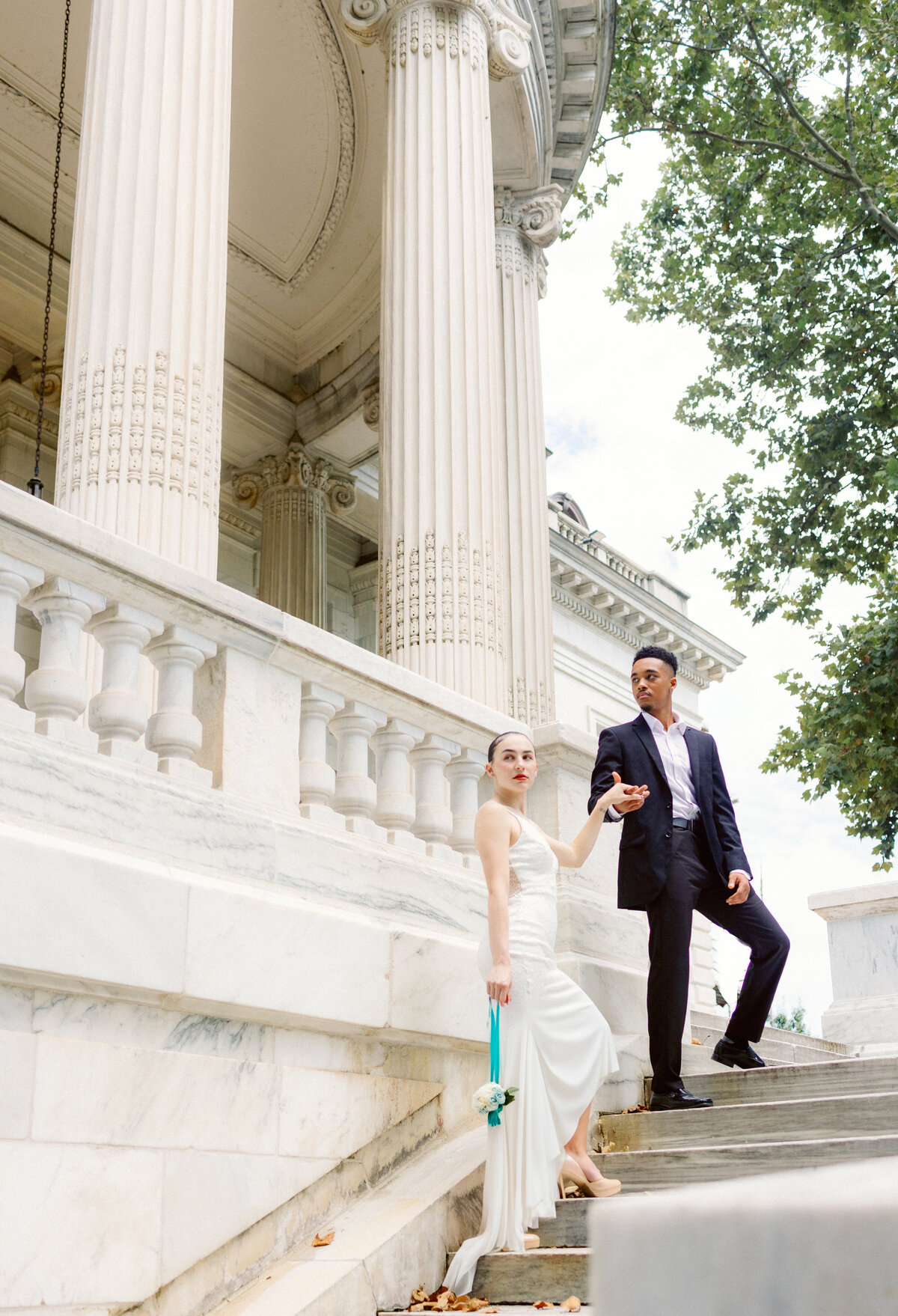 bride and groom stand on stairs at venue