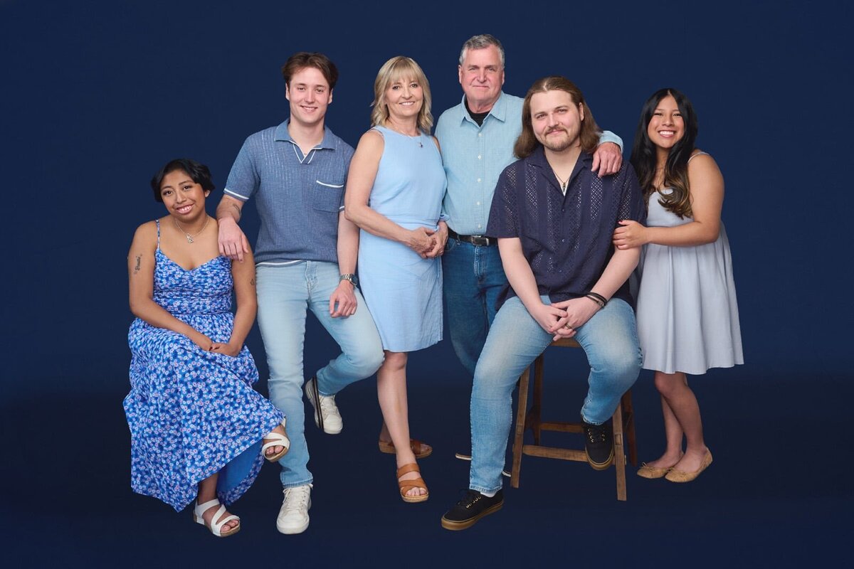 Smiling Family Portrait in Blue Against a Dark Background-91