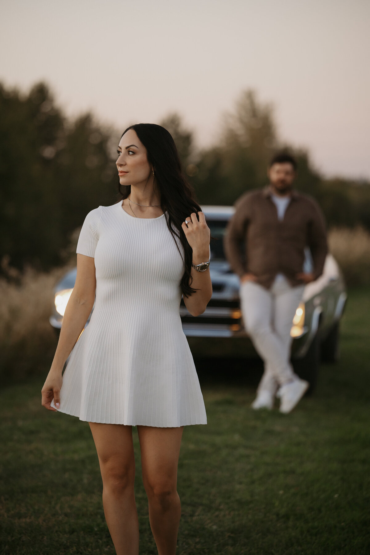 Engagement photograph of girl with her partner and his car in background