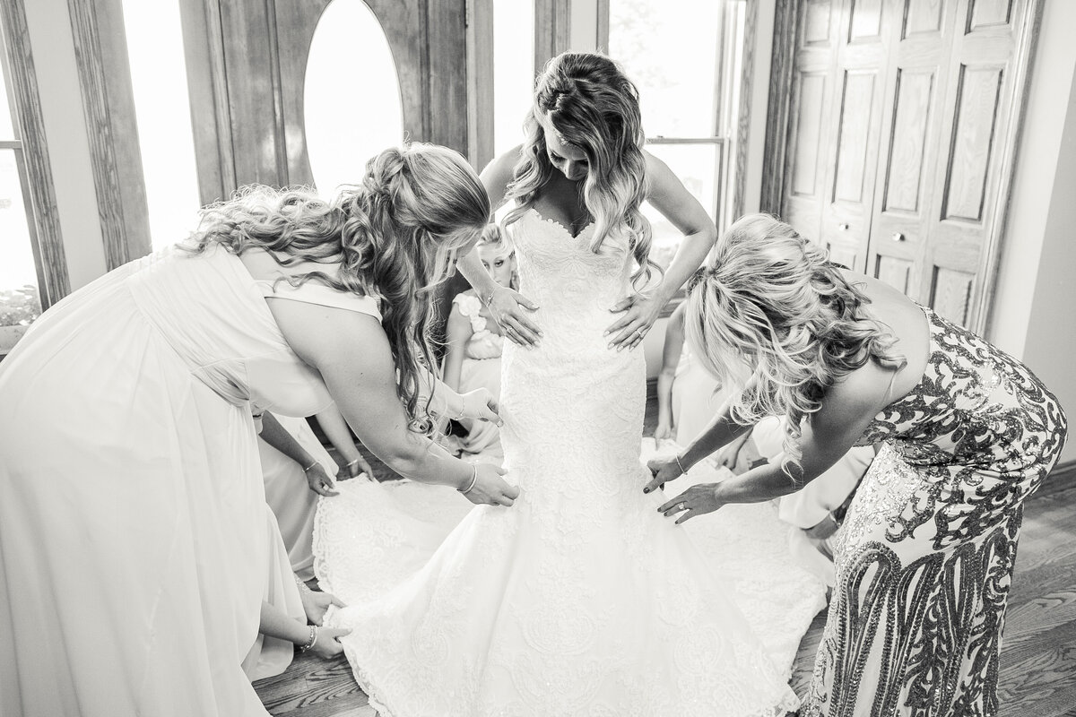 njeri-bishota-lauren-ashley-bride-putting-on-dress-bridesmaids-helping-black-and-white