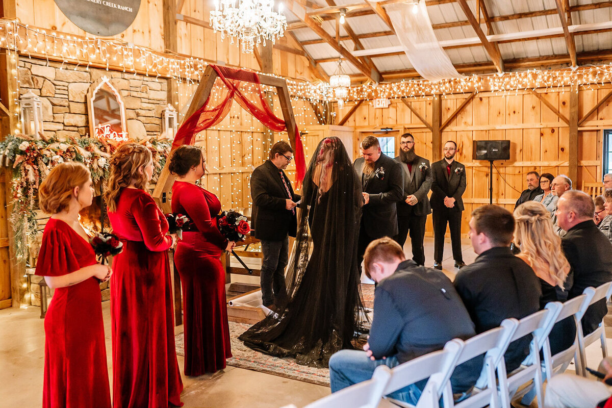 Gothic-themed wedding ceremony with black veil and red decor