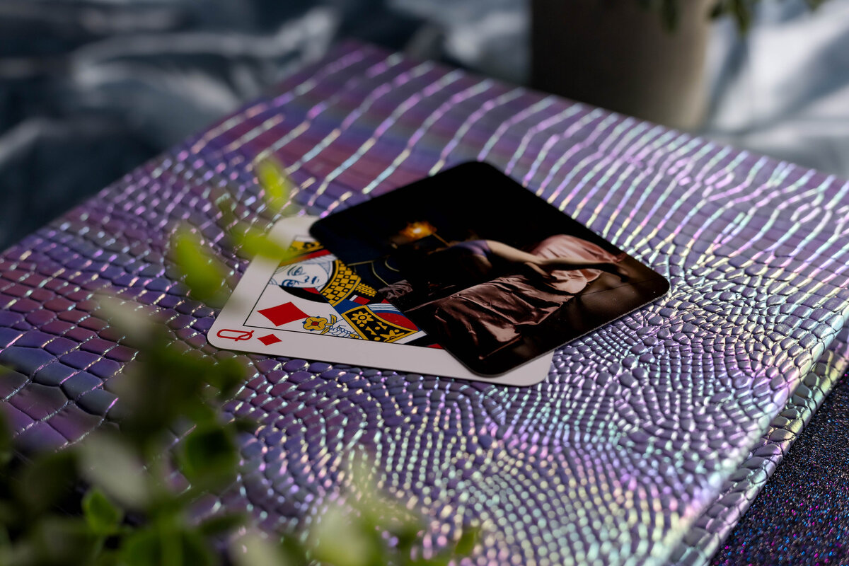 Rainbow-colored snakeskin boudoir album in purple tones, accompanied by custom playing cards, showcasing a unique and vibrant keepsake from Joclyn’s photography.