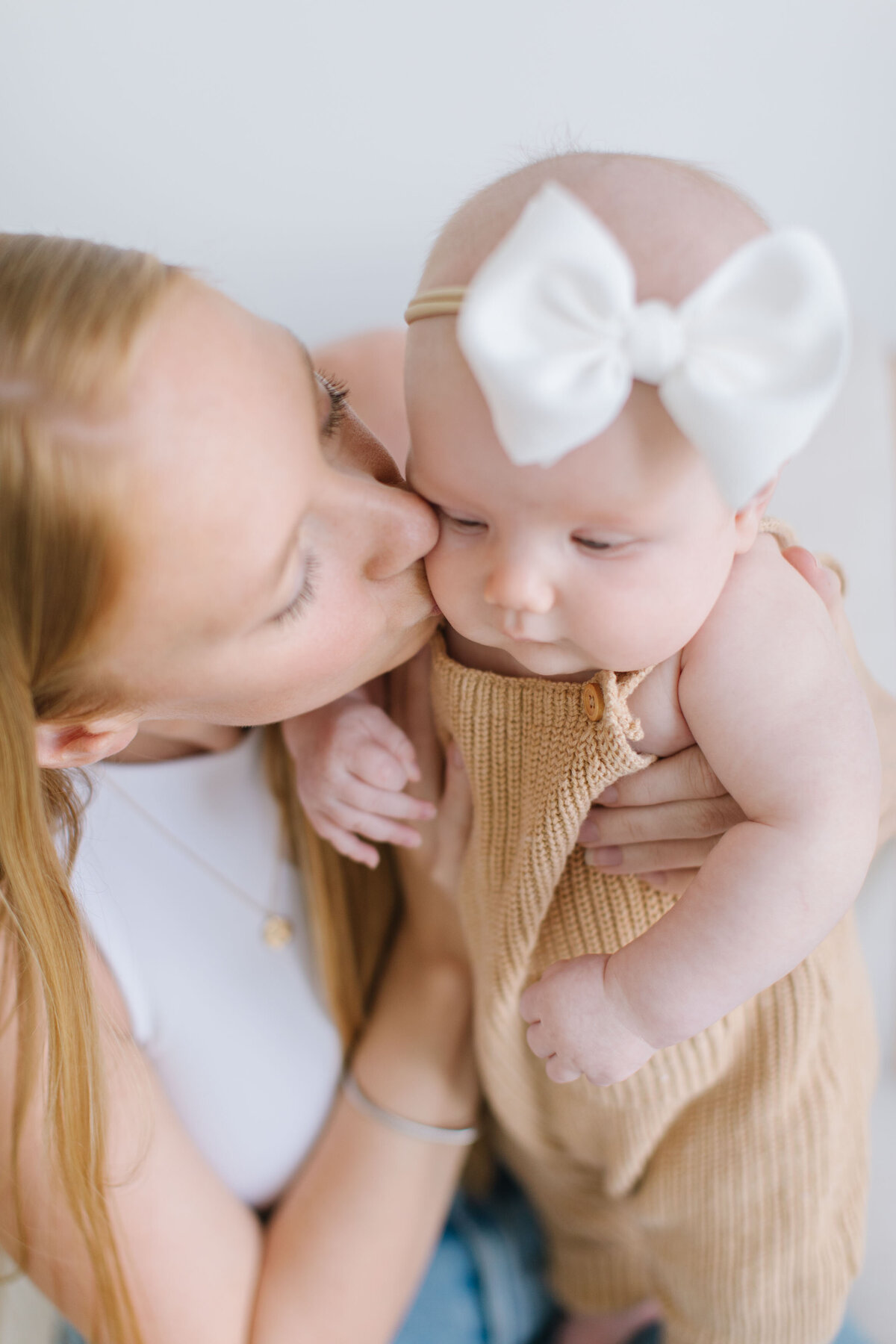 mother kissing baby cheeks at  photography studio in northern virginia