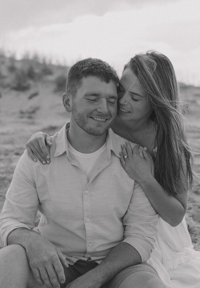 Girl leans over shoulder of her husband and whispers in his ear