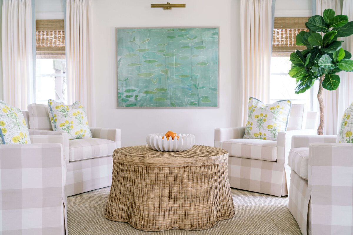 oyster creek studios happy valley white chairs around a wooden dining room table with white and green rug light plaid chairs around a wicker coffee table around a modern painting in living room