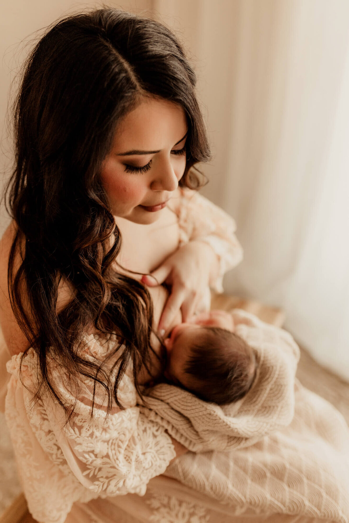 Mother nurses her newborn baby boy.