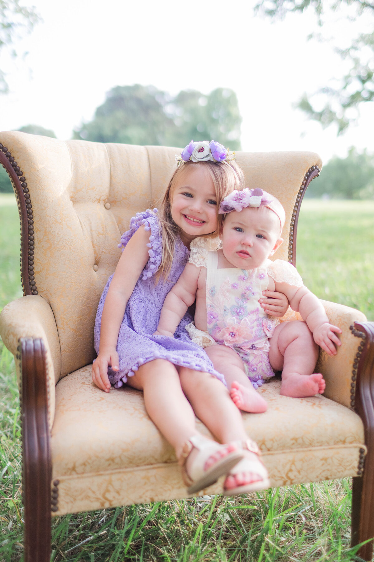 Sisters cuddled up together on chair during family photo session in Mooresville NC