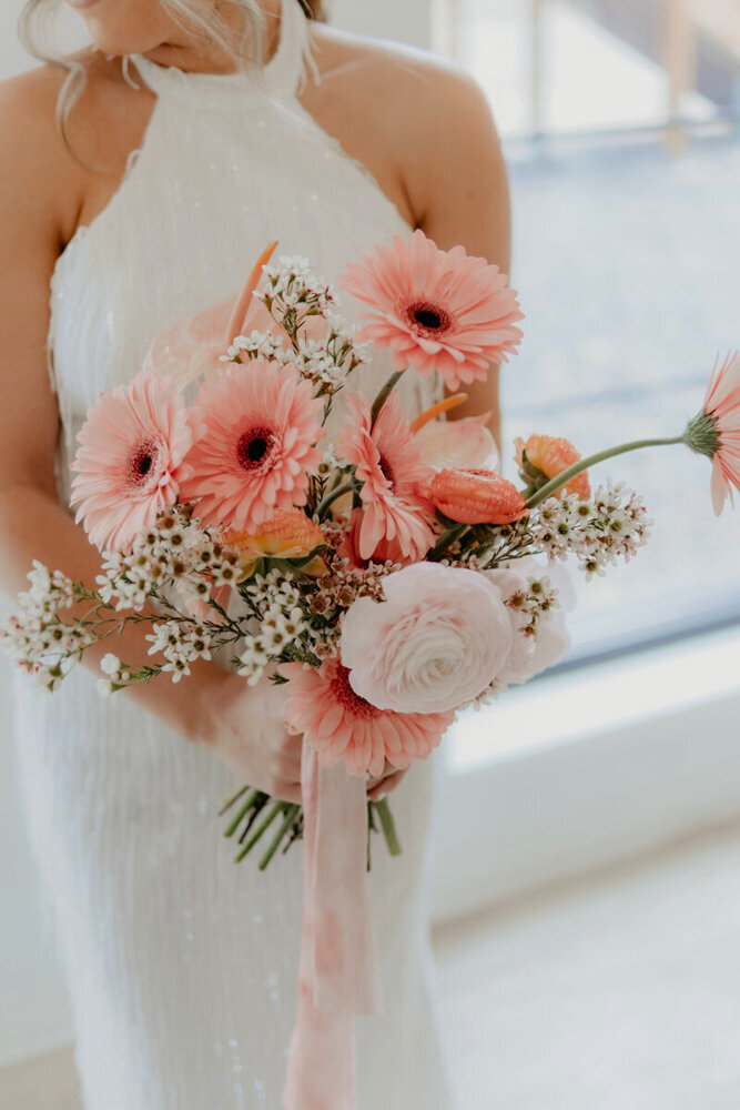 bride-holding-modern-pink-wedding-bouquet-pinewood-weddings-and-events-cambridge-minnesota-des-moines-photographer-storyteller-collective-photo-co