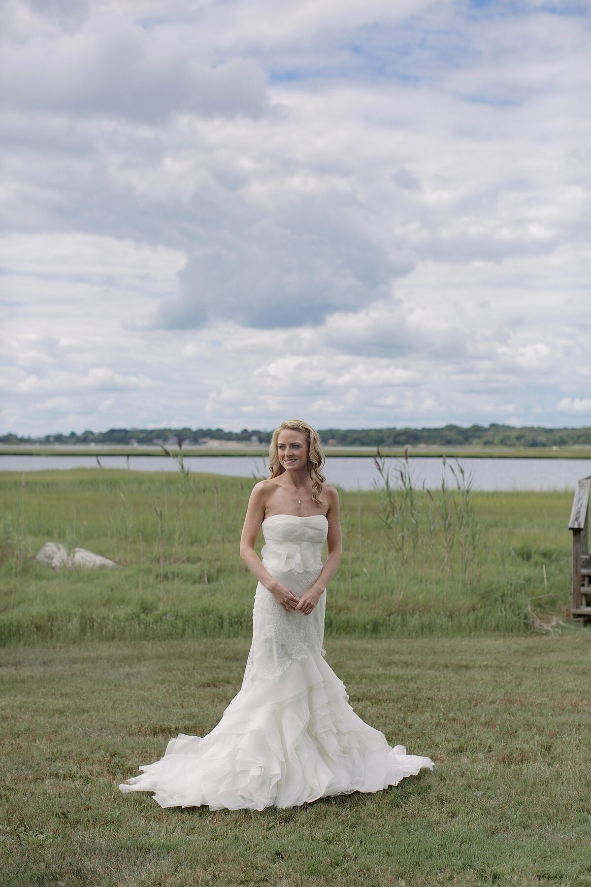 Bride poses near the dunes during Cape Cod wedding.