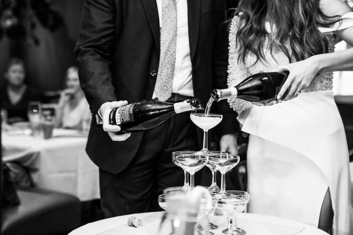 Downtown-Mobile-Alabama-Wedding-Photographer-Videographer-Dauphins-Rehearsal-Dinner-Bride-Groom-Champagne-Pour-BW