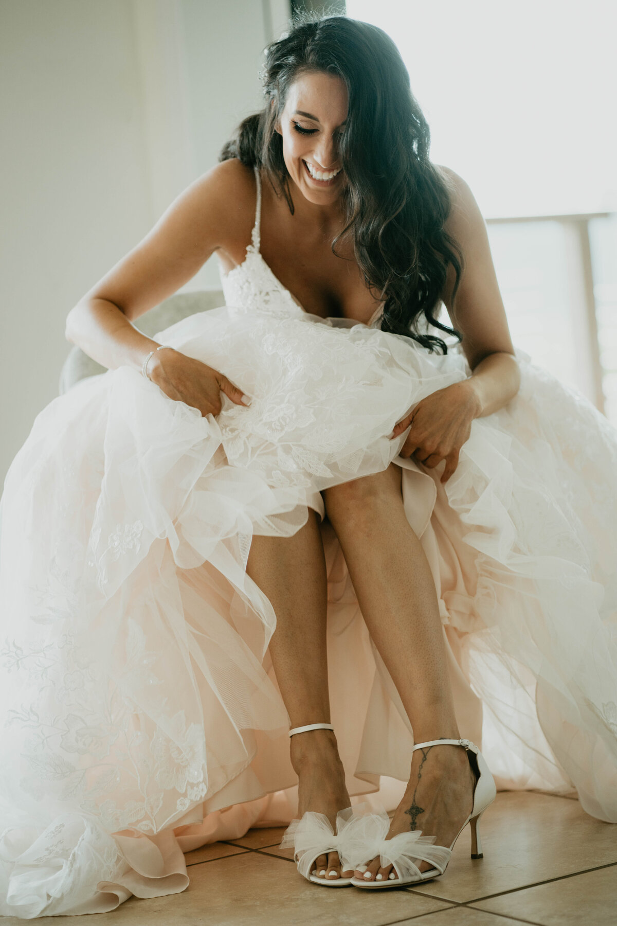 Bride putting her shoes on while getting ready before vineyard wedding