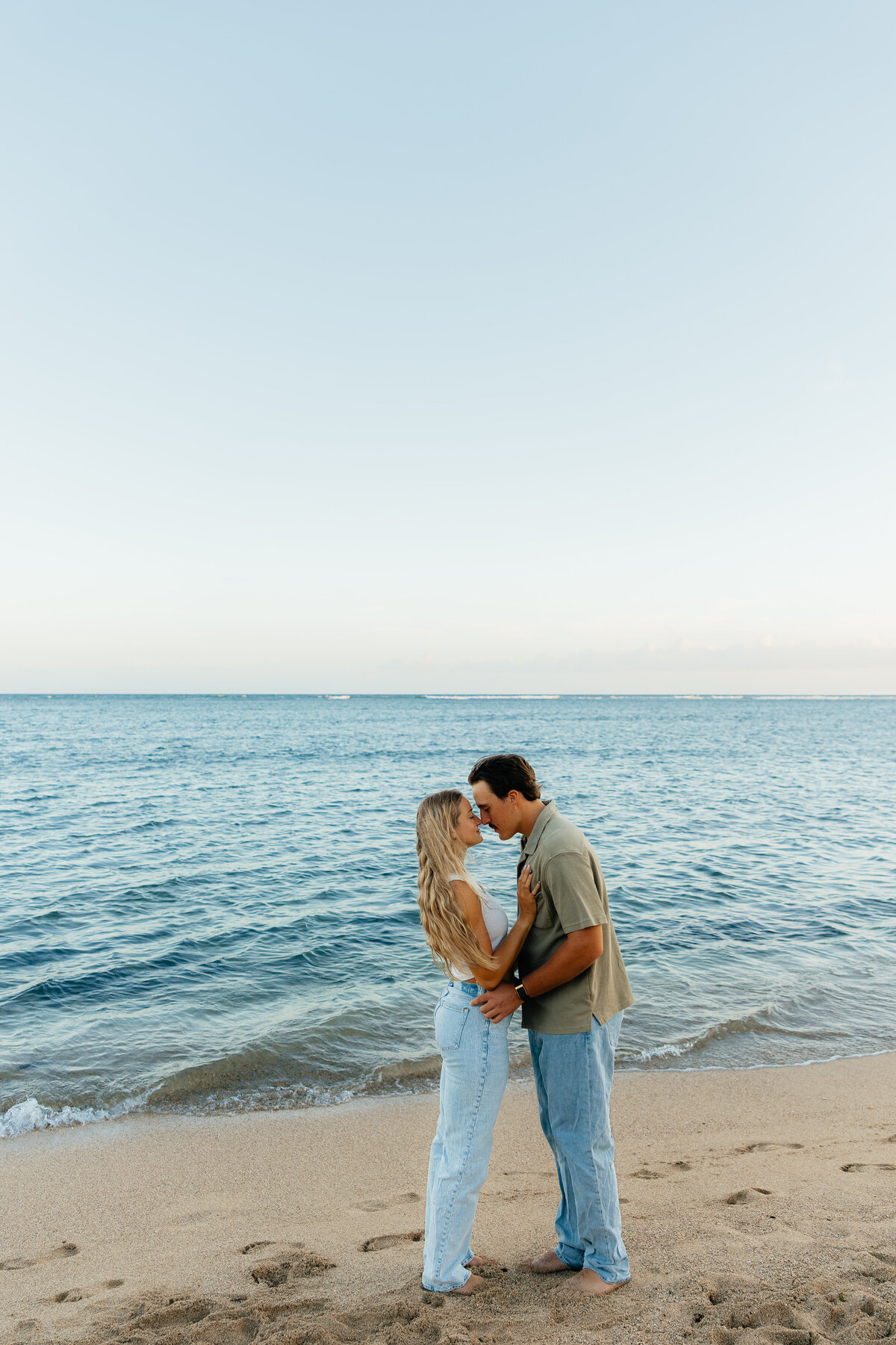 Couple embracing with beautiful ocean backdrop behind them in Honolulu