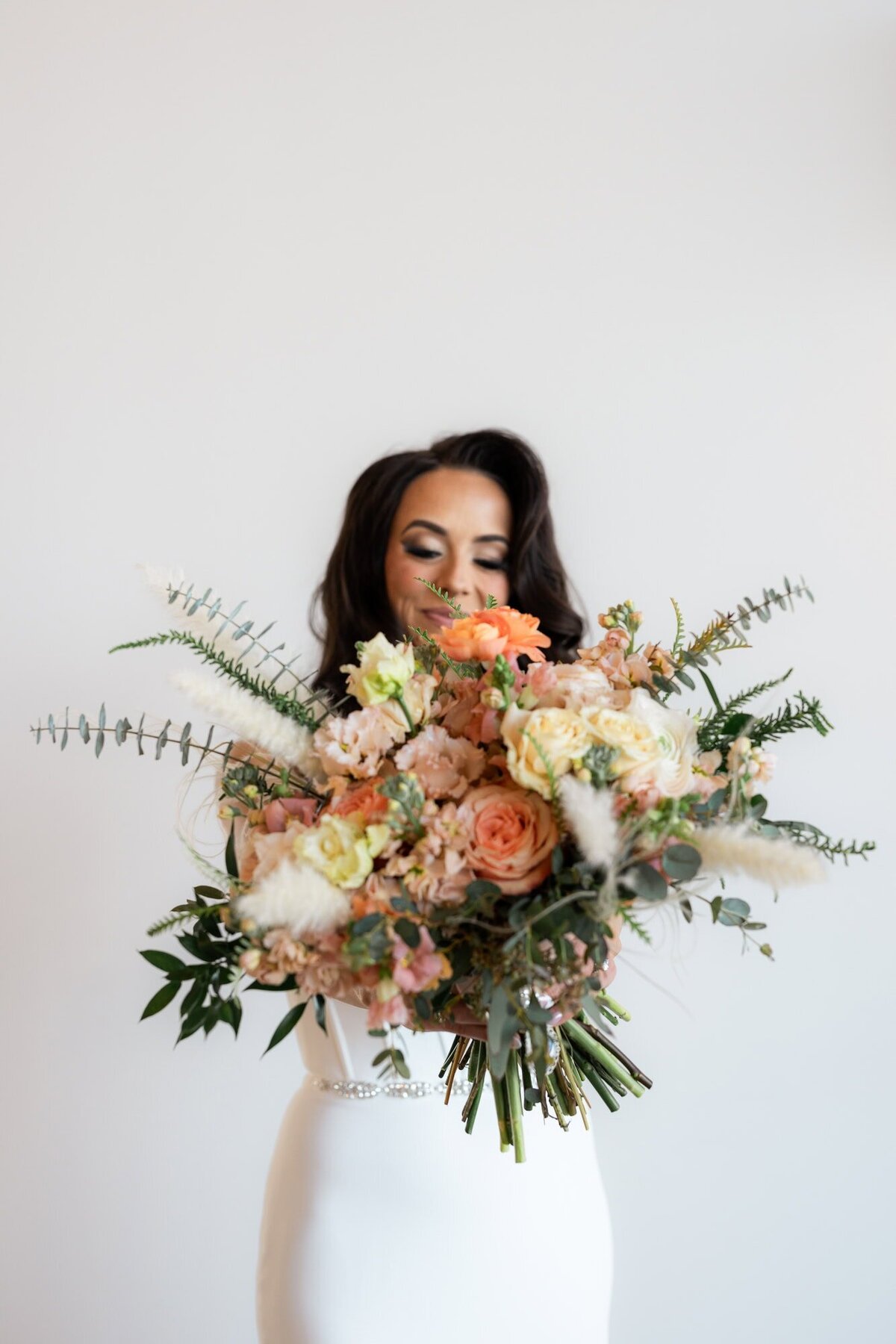 Bride holding her bouquet out to the camera.