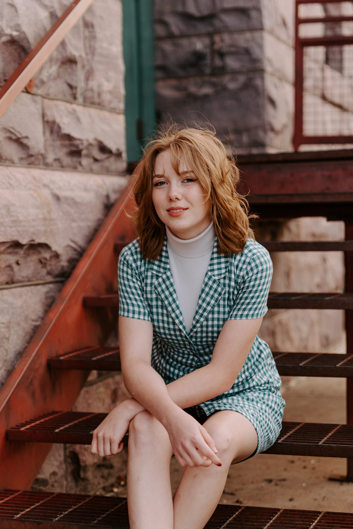 A young girl sitting on metal steps