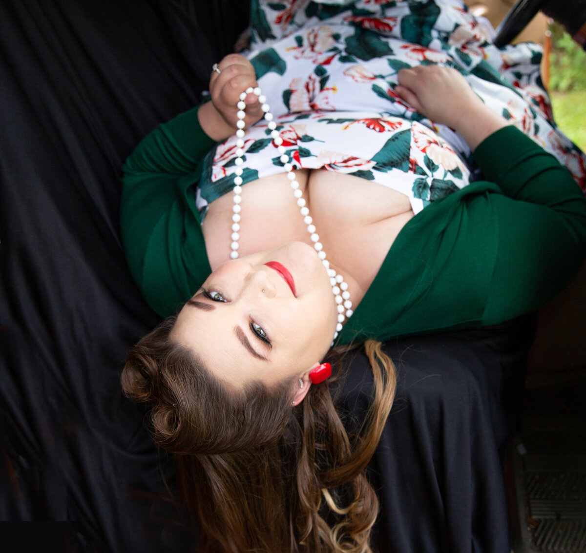 goddess studio boudoir woman pinup style white beads red lipstick pinup hair dark green cardigan front seat