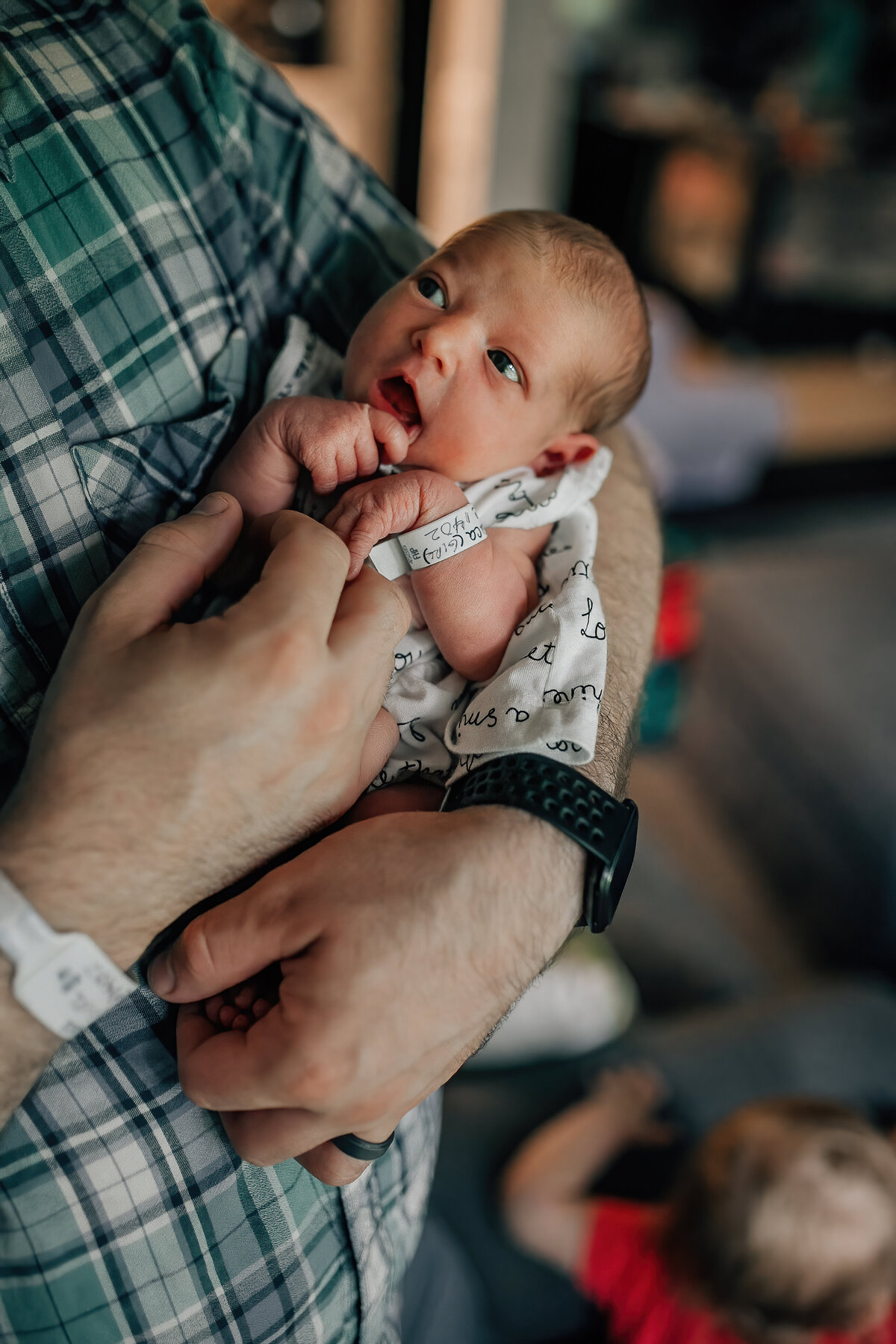 Newborn photography of a baby being held by dad.