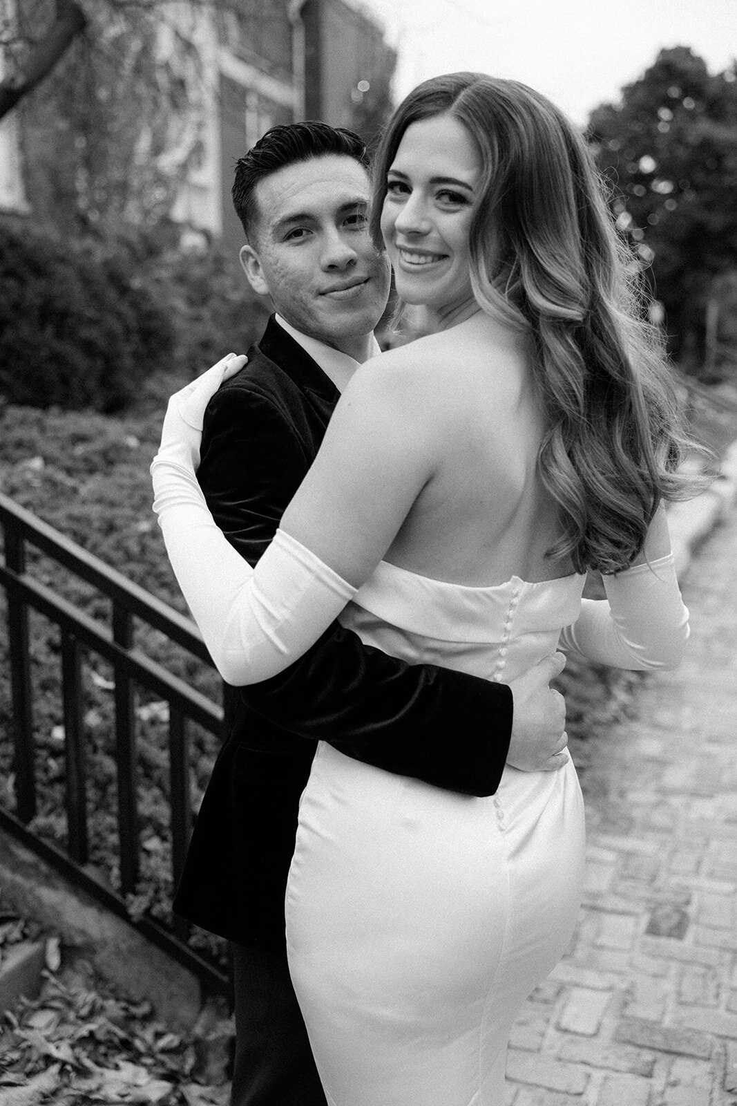 A bride and groom hold each other while looking directly into the camera on their elopement day. 