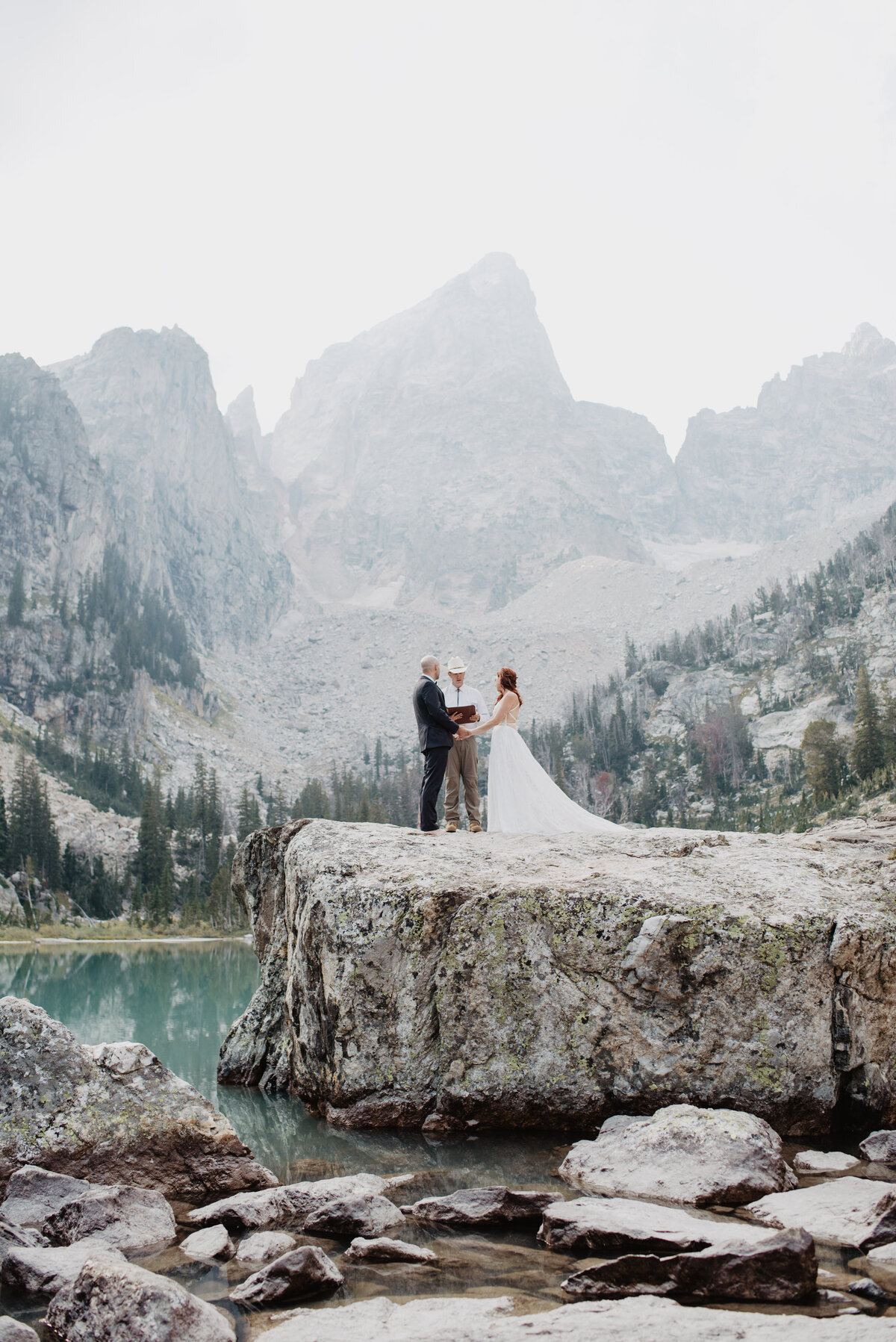 Jackson Hole photographers capture bride and groom holding hands during ceremony