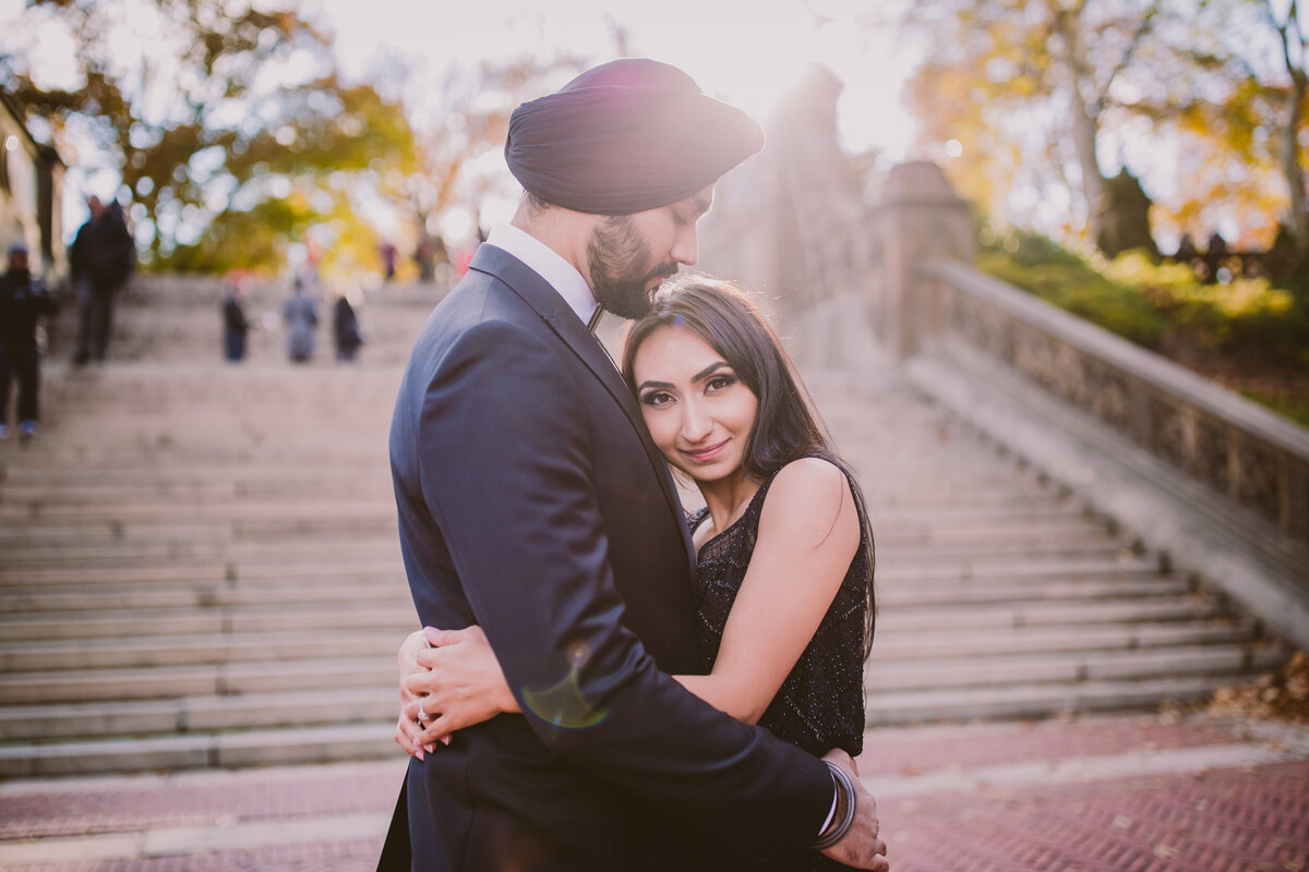 A sikh couple sharing a moment at the central park bethesda terrace in black formal clothing during their engagement session