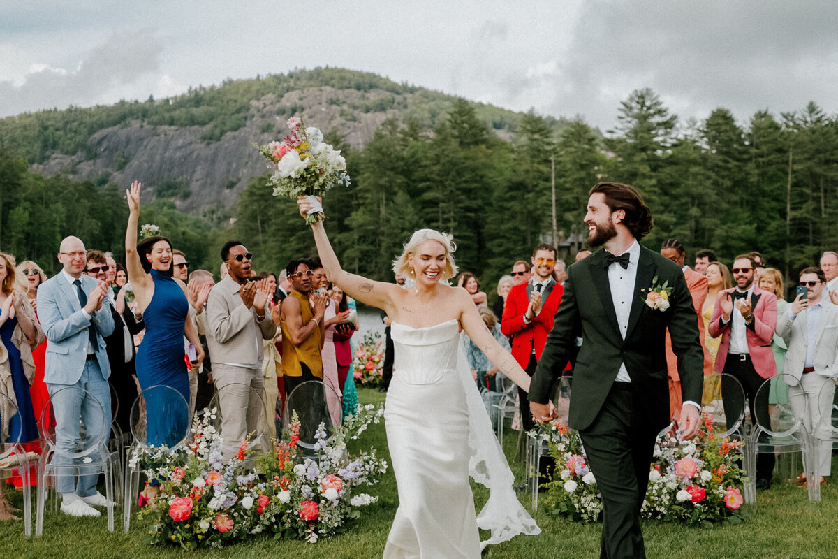 Bride and Groom celebrate as they exit their wedding ceremony in the mountains