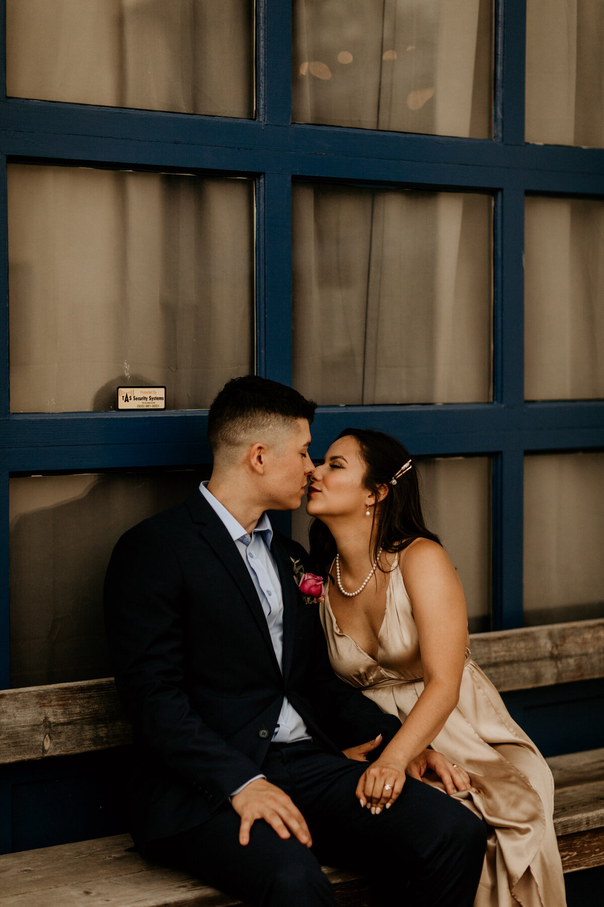 bride and groom sitting together at an abandoned  mechanic shop