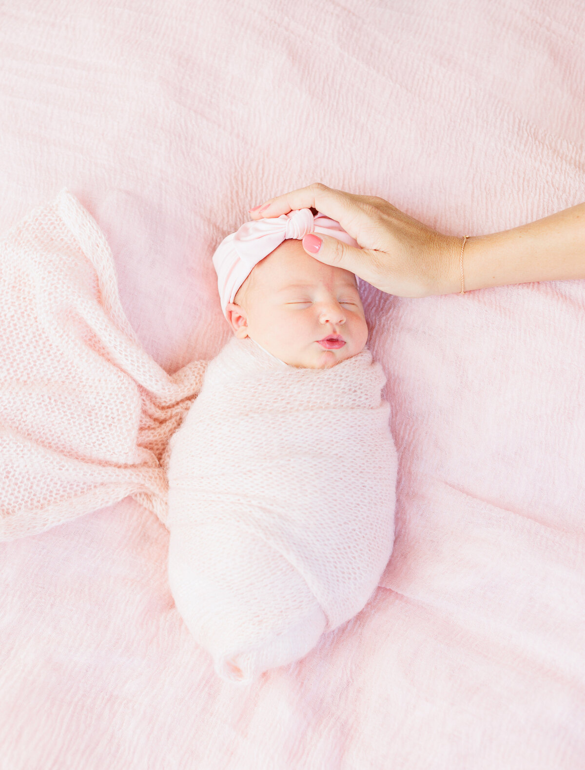 Newborn wearing pink sleeping