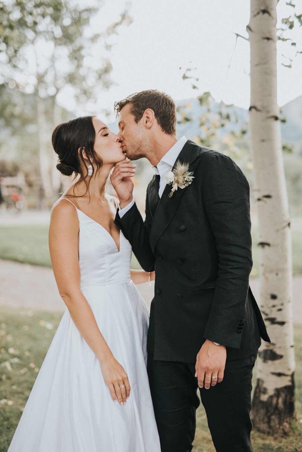 Bride and groom sharing a kiss in front of aspen trees in Colorado