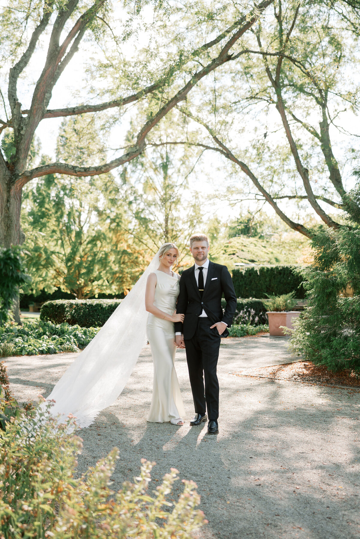 Bride and groom pose together under trees in Dayton, Ohio, wedding portrait by Philadelphia wedding photographer.