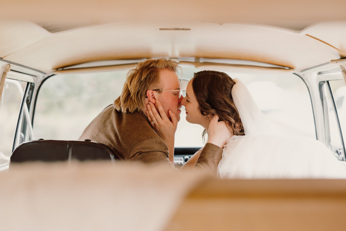 man and woman kissing inside of  VW bus