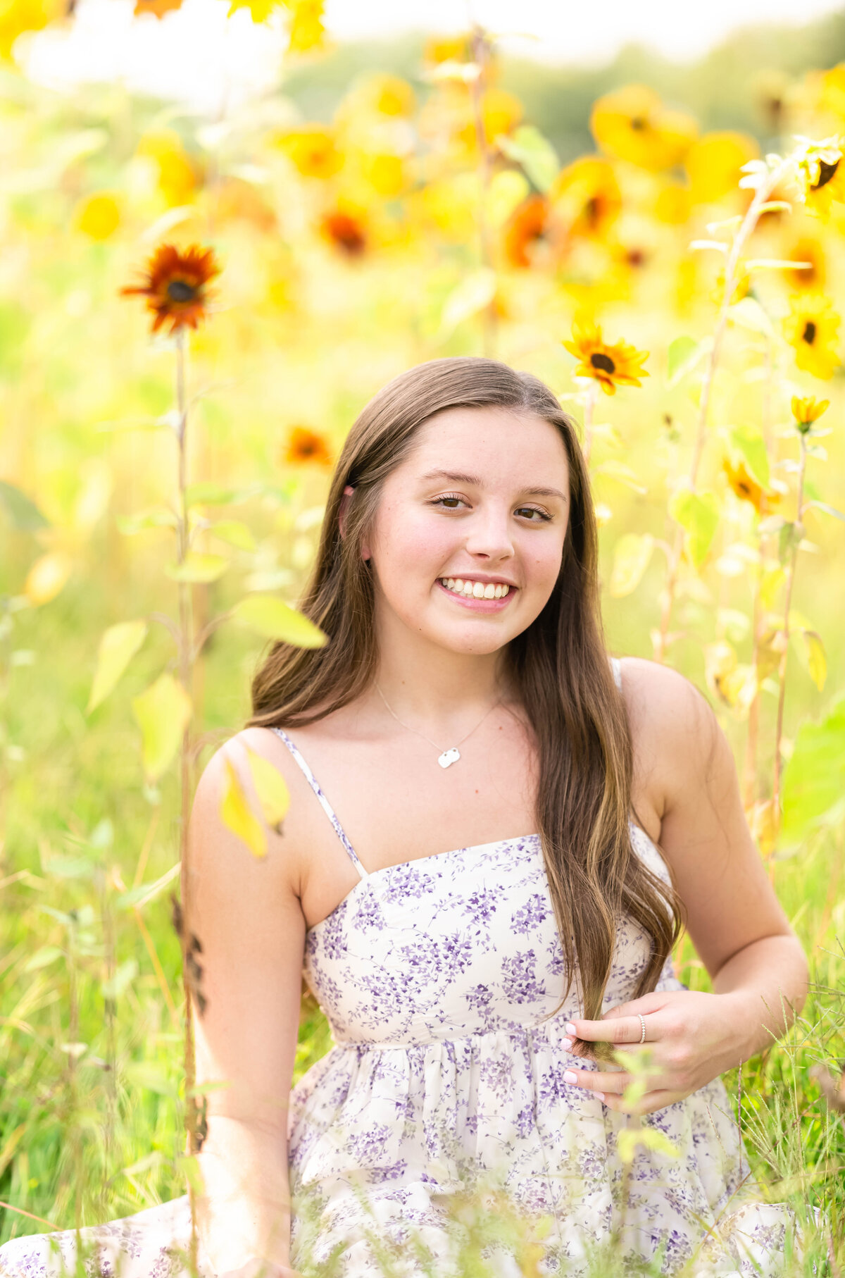high school senior girl smiling in flower field