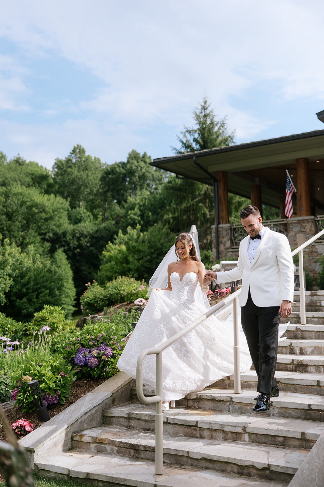 Bride and groom walking down the stone steps at Trillium Links & Golf Club in Cashiers, NC during their wedding day portraits.